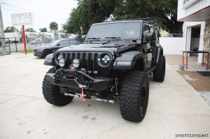 Black-Jeep-Next-Level-Inc-Custom-Install-RIGID-Morimoto-lights-Alpine-speakers-Full-Driver-Side-Front-Bump-Custom-Lighting-RIGID-Fox-Suspension-Profile