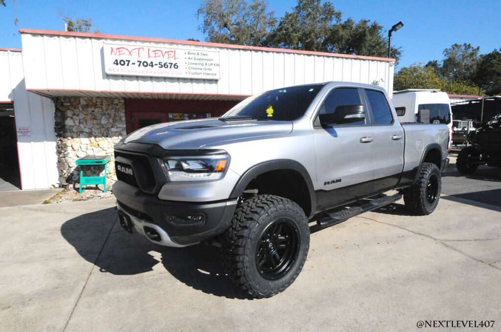 Next Level Silver Dodge Ram Vertex Rough County Suspension and Toyo Open Country Tire Install Orlando Store Front Profile